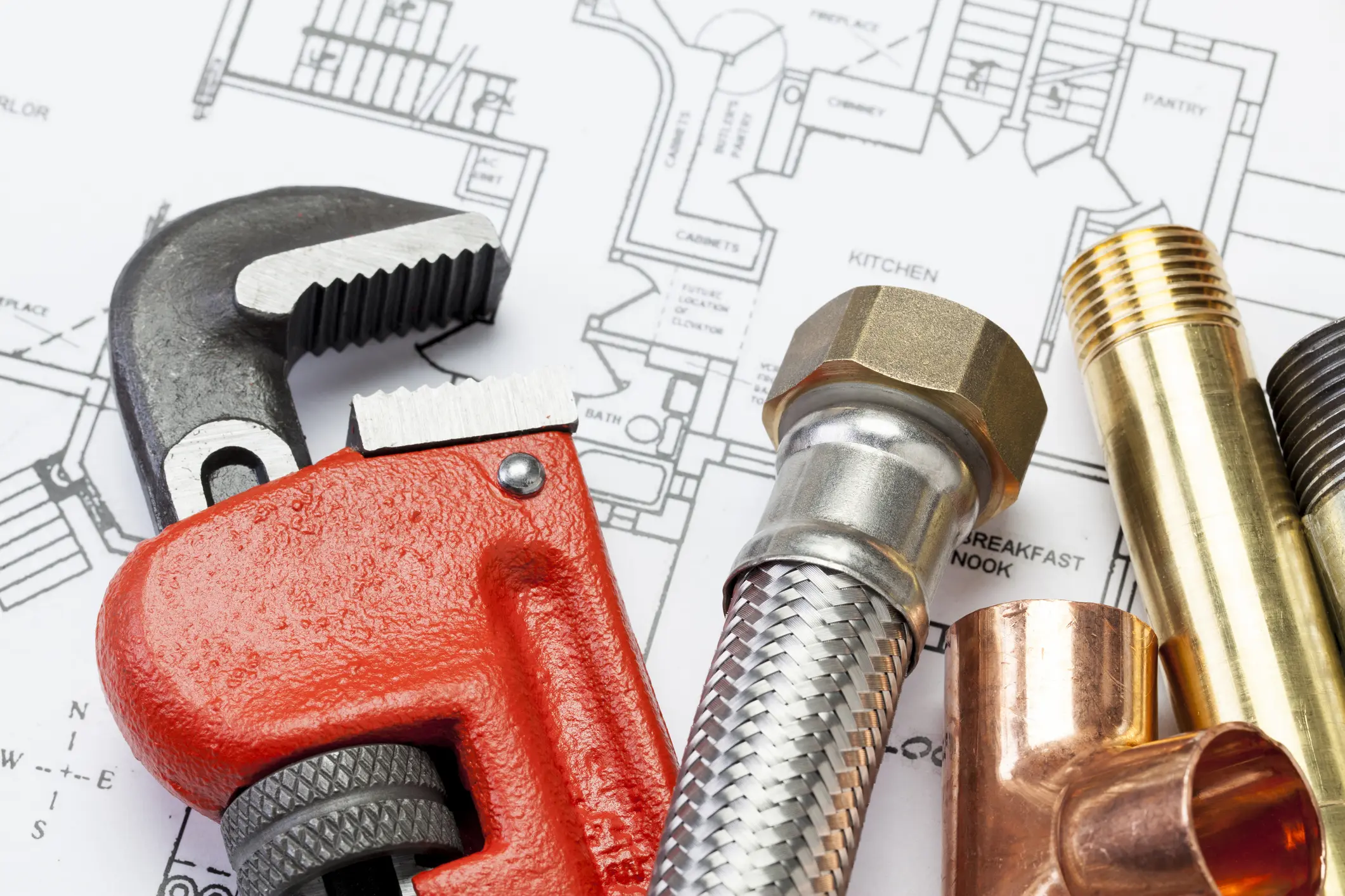 Red pipe wrench and plumbing fittings on home plan — Oil City Plumbing