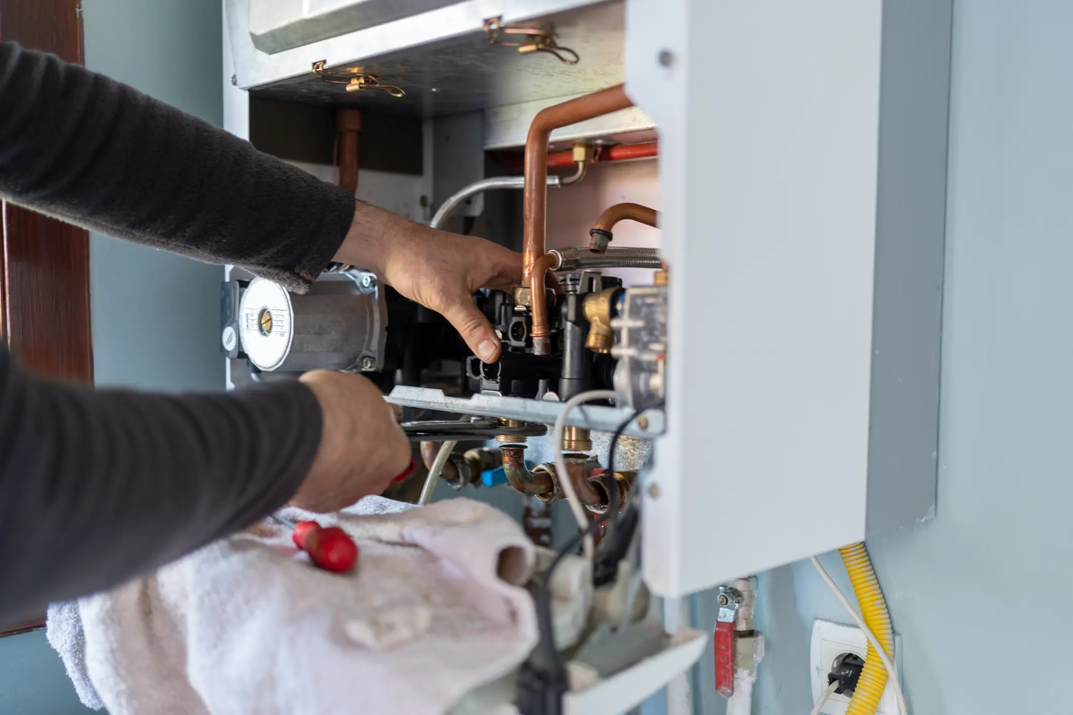Plumber repairing copper water heater lines in Mills WY home
